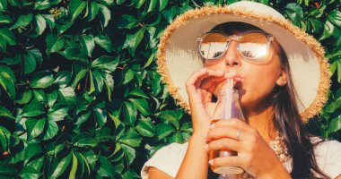 Yabani üzüm duvar arka plan üzerinde suyu duran güzel kadınla