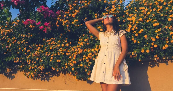 Schöne Frau auf den Blumen Wand Hintergrund — Stockfoto