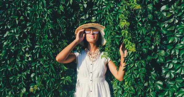 Bella donna in occhiali da sole la parete di uva selvatica sfondo — Foto Stock