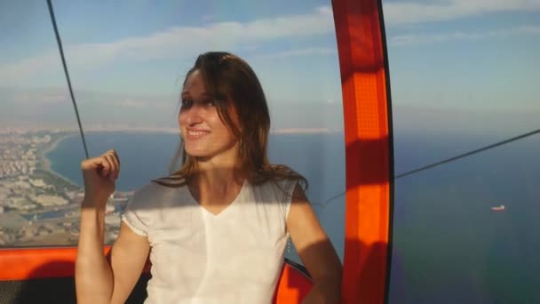 Jonge vrouw toeristische zitten in de kabelbaan op de weg naar de top van de Kunektepe Teleferik — Stockvideo