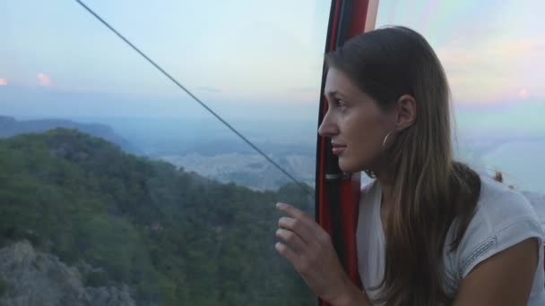 Jeune femme touriste assis dans le téléphérique tout en descendant — Video