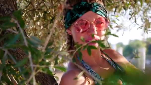 Young hippie woman with sunglasses sitting on the tree — Stock Video