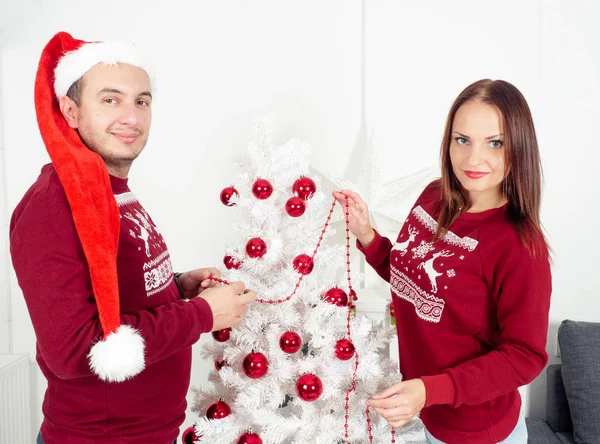 Casal sorridente decora árvore de Natal — Fotografia de Stock