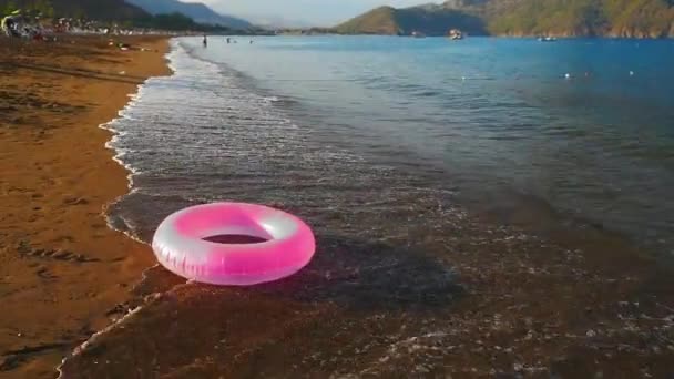 Розовый надувной круг на пляже — стоковое видео