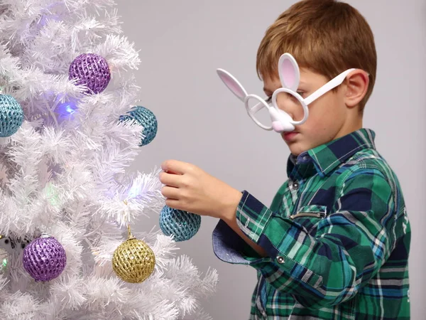 Díszítő karácsonyi fa gyöngyök fiú — Stock Fotó
