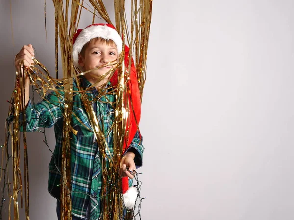 Chłopiec w Boże Narodzenie kapelusz stojący złoty łańcuch — Zdjęcie stockowe