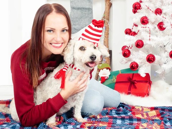Bela mulher se divertindo com seu cão, tanto em roupas de Natal — Fotografia de Stock
