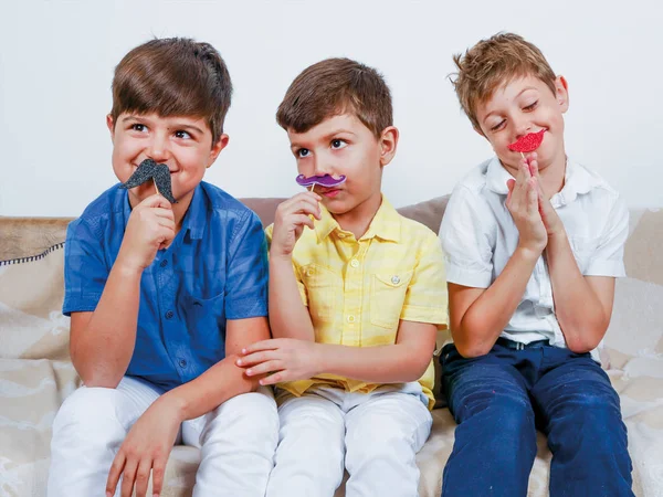 Crianças felizes posando com bigodes e óculos engraçados — Fotografia de Stock