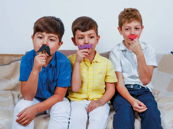 Crianças felizes posando com bigodes e óculos engraçados — Fotografia de Stock