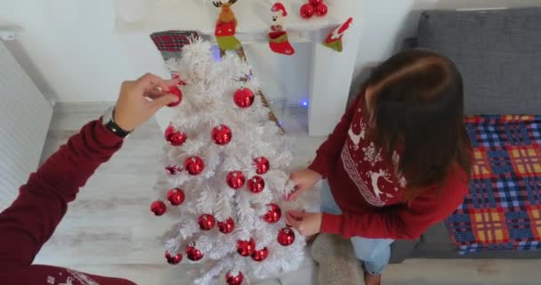 Casal feliz em roupas de Natal decorando árvore Christmass branco — Vídeo de Stock