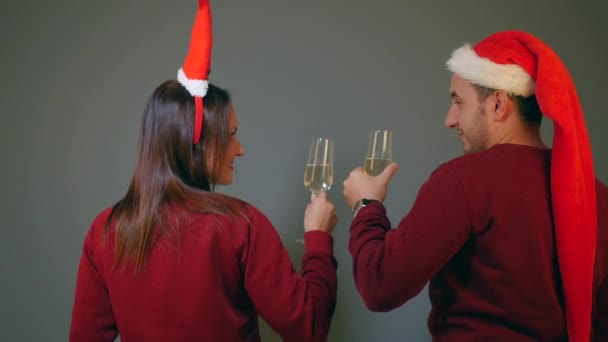 Pár santa kalap pezsgő szemüveg csengő és ünnepli az új év — Stock videók