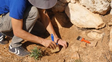 Genç arkeolog bir arkeolojik site çalışır