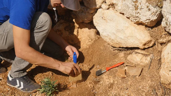 Joven arqueólogo trabaja en un sitio arqueológico — Foto de Stock