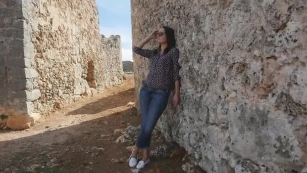 Jovem mulher apoiada em uma parede texturizada velha — Vídeo de Stock