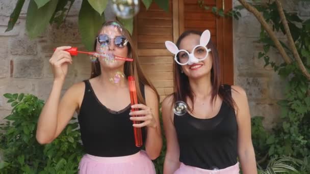 Jonge grappige vrouwen partij bellen blazen op de camera — Stockvideo