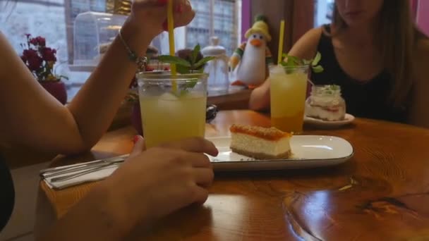 레모네이드를 마시고 카페에서 케이크를 먹는 젊은 여성 — 비디오