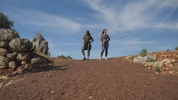 Молоді жінки, що стоять у центрі кам'яної дороги — стокове відео