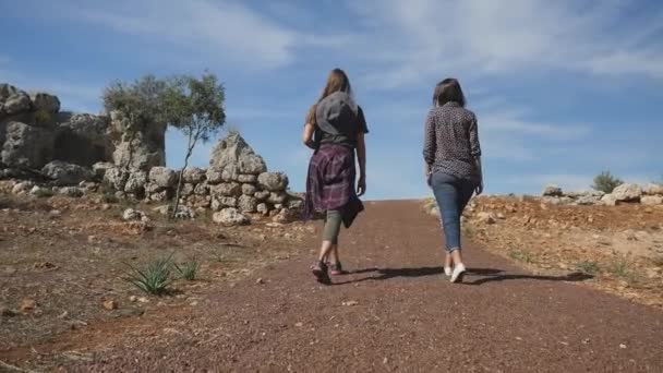 Jonge vrouwen foreward te lopen op de weg van puin — Stockvideo