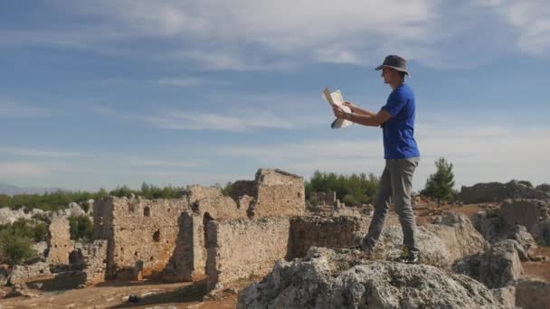 Νεαρός ταξιδιώτης με χάρτη κοιτάζοντας πολύ μακριά — Αρχείο Βίντεο