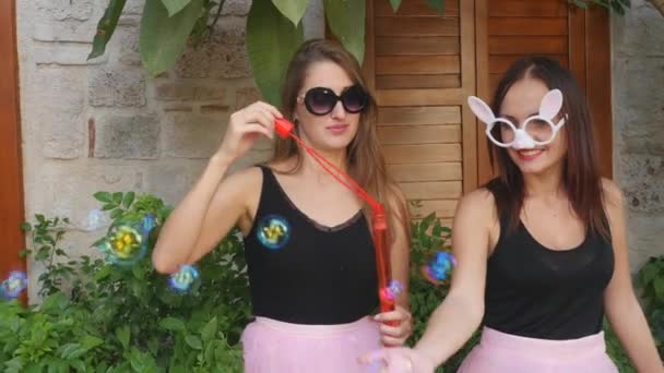 Young funny women blowing party bubbles at the camera — Stock Video