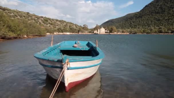 Een houten rij boot vastgebonden aan een pier — Stockvideo