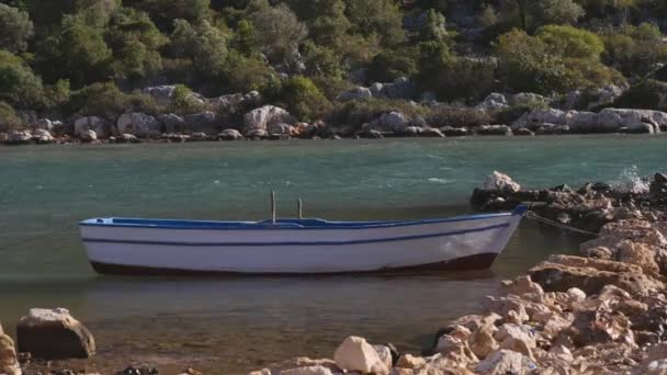 Una barca a remi in legno legata a un molo di pietra naturale — Video Stock