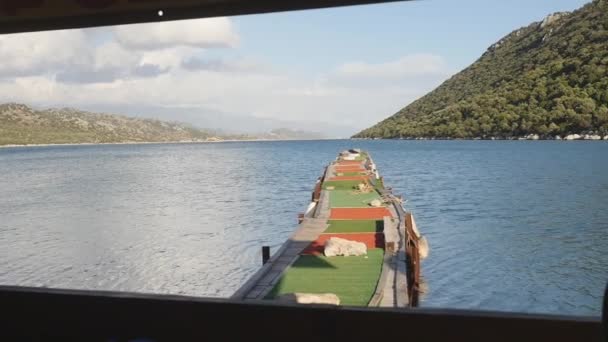 Gammal träpir i havet med berg på backgorund i slow motion — Stockvideo