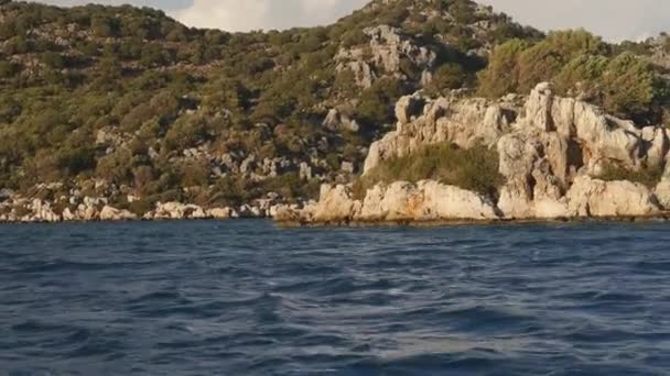 Путешествие на лодке против скал в море — стоковое видео