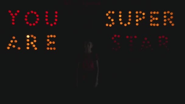 Junge posiert auf der dunklen Bühne Superstar — Stockvideo