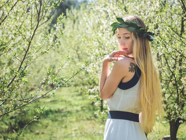 Young beautiful smiling woman in spring blossom trees. — Stock Photo, Image