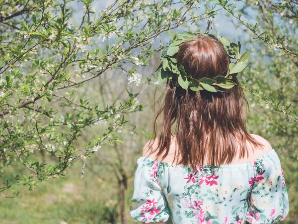 Backview of young beautiful woman in spring blossom trees. — Stock Photo, Image