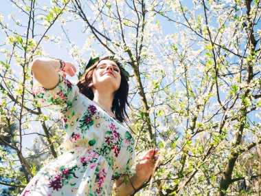 Young beautiful woman in spring blossom trees dreaming