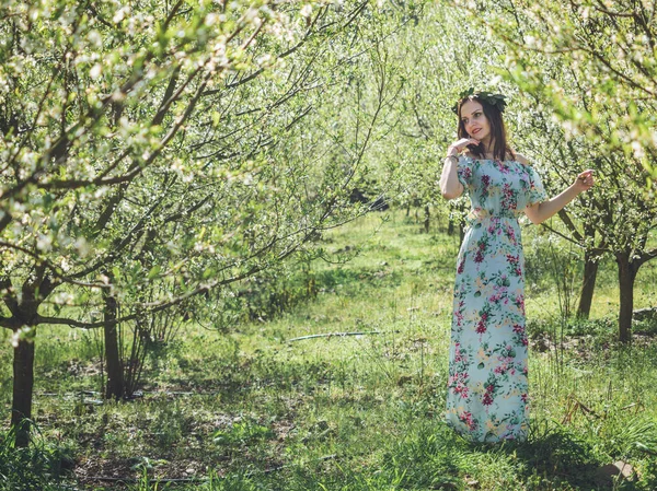 Junge schöne brünette Frau im langen Kleid Frühling blühen Bäume. — Stockfoto