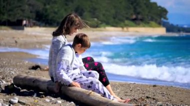 Woman with little son sitting near the sea