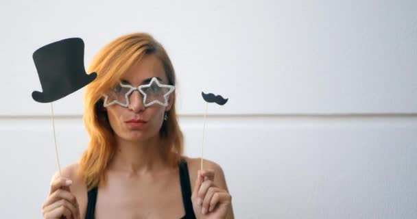 Молодая женщина в карнавальных масках на палочках — стоковое видео