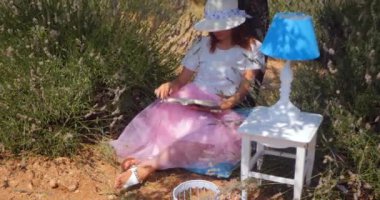 Young woman laying reading a book under the tree