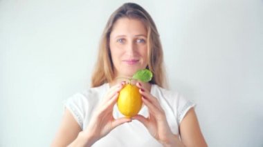 Defocused genç kadın taze limon gösteren