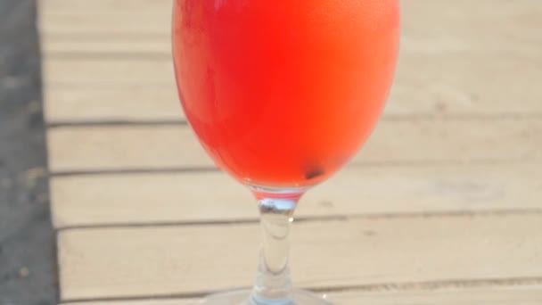 Verfrissende oranje cocktail op strand tafel. — Stockvideo