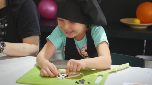 Chica en chefs sombrero en la cocina durante las clases de cocina — Vídeos de Stock