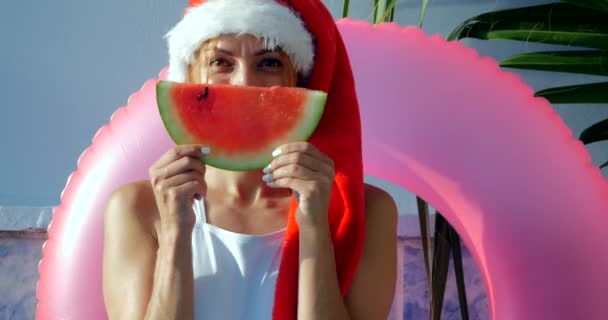 Krásná mladá žena v plavkách v Santa klobouku — Stock video