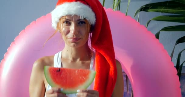 Beautiful young woman in Santa hat in swimsuit — Stock Video