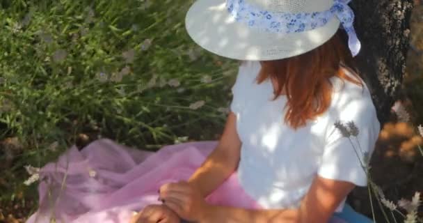 Молода жінка лежить і спить під деревом — стокове відео