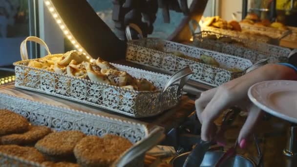 Buffet de comida en un hotel de lujo. Tomar galletas — Vídeos de Stock