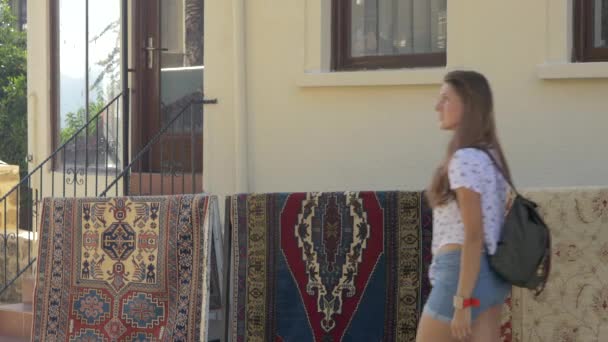 Молодая женщина в летней повседневной одежде гуляет одна по центру города — стоковое видео