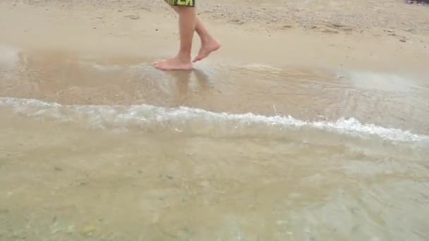 Male feet step on the sea wave — Stock Video