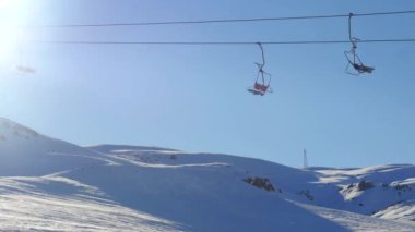 Hareketli sandalye asansörü ve karlı dağdan snowboard sportif insanların hızlı hareket