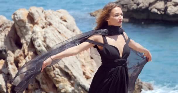 Όμορφη γυναίκα με μαύρο κασκόλ σε κομψό μαύρο φόρεμα — Αρχείο Βίντεο