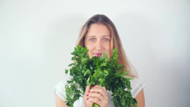 Portrait of a beautiful happy young woman with a bouquet of fresh parsley — Stock Video