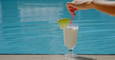 womans hand stir cocktail