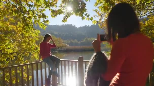 Junge Frauen machen ein Foto auf der Seebrücke — Stockvideo